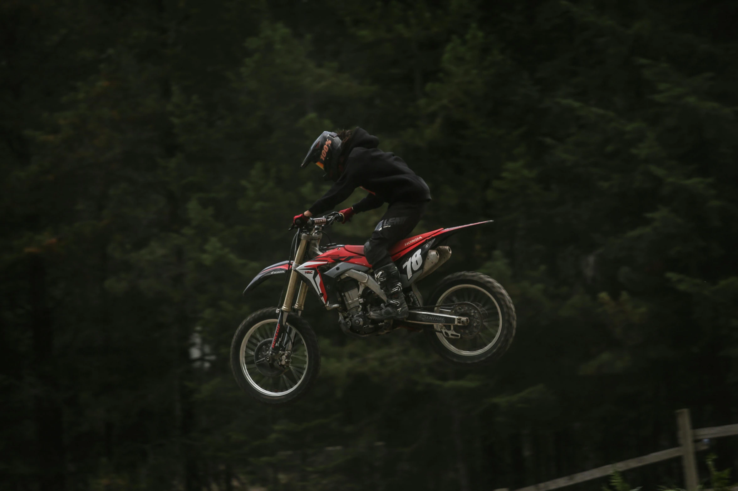 a man flying through the air riding on top of a dirt bike