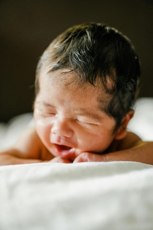 a baby boy is asleep on top of a bed