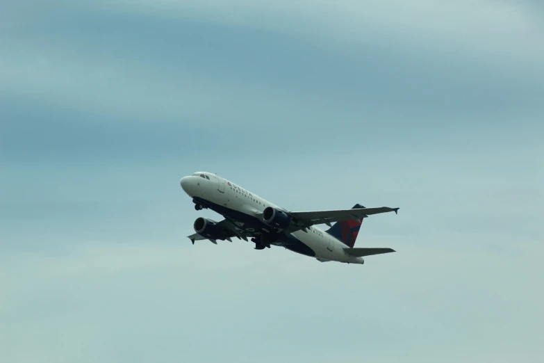 a jetliner flying through a blue sky with clouds