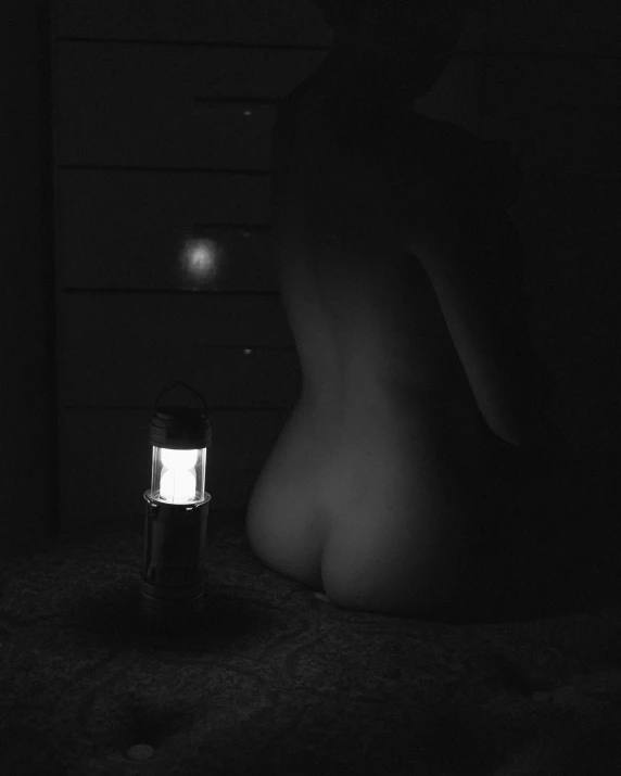the image is dark and has a person laying  and a lamp