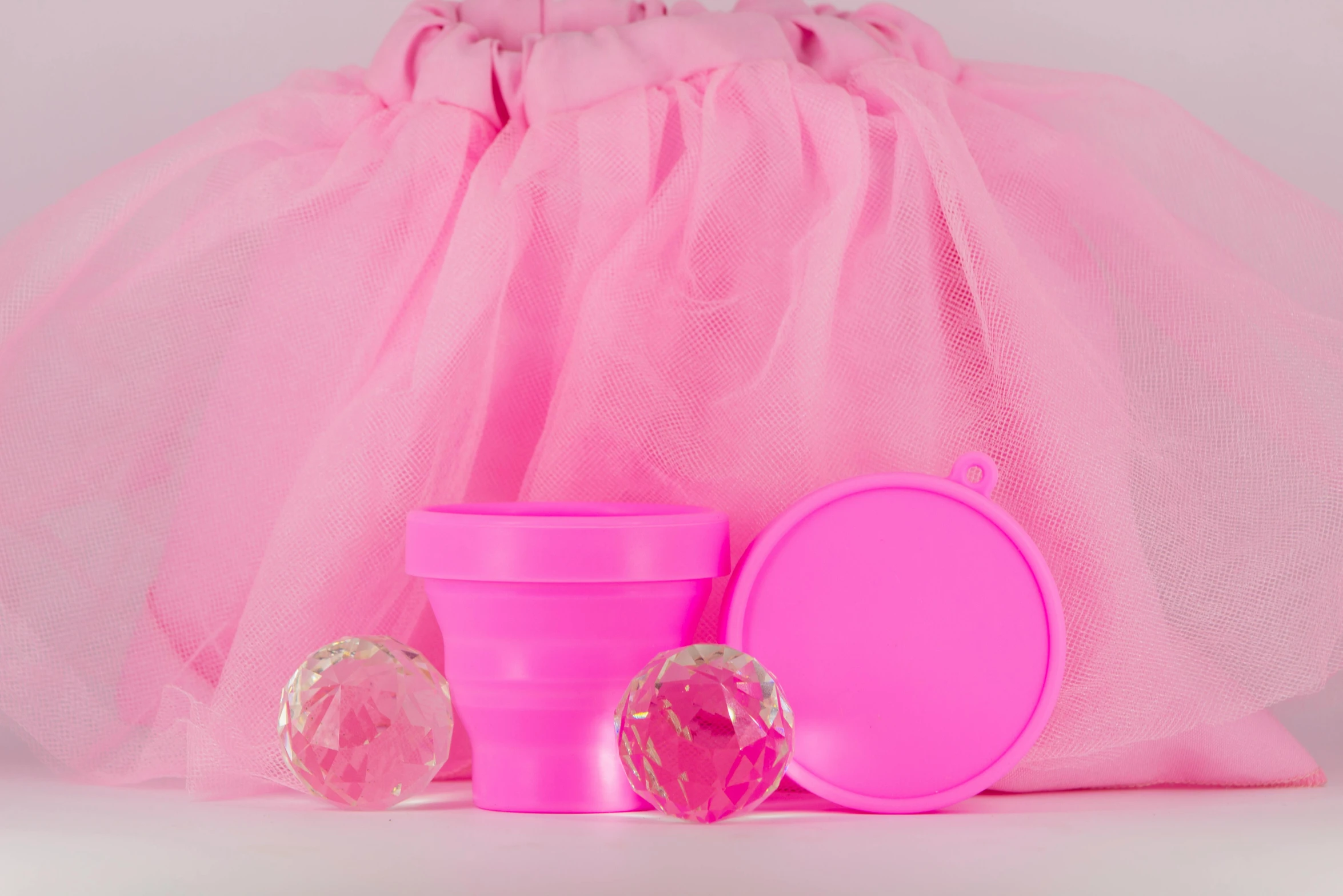 a tulle with several small objects and one pink cup