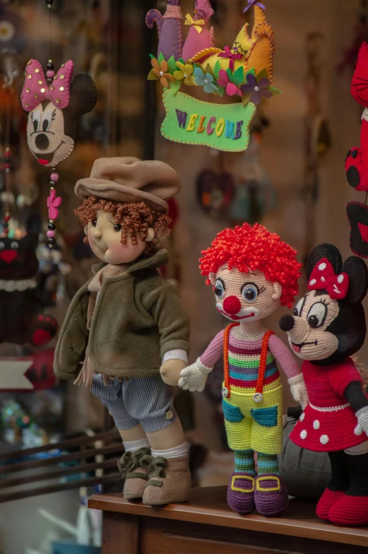 three stuffed toys are displayed on the shelf