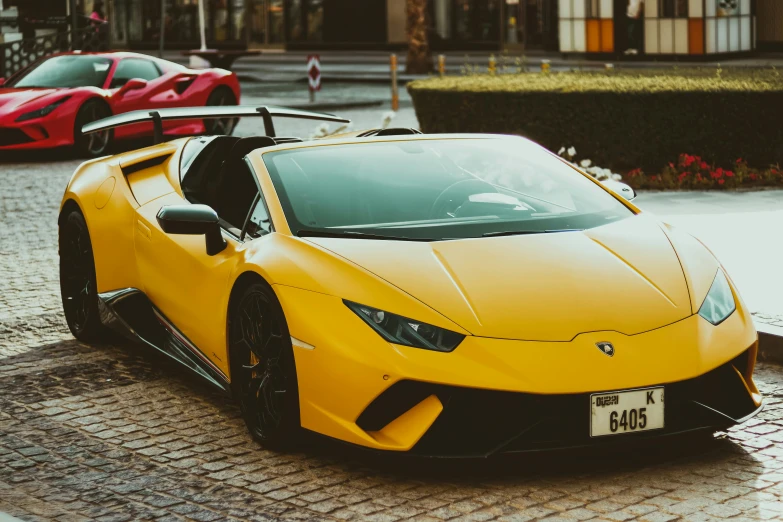 the front of a yellow sports car on the street