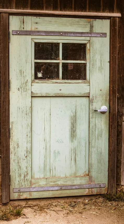 a barn door with two windows is partially shut