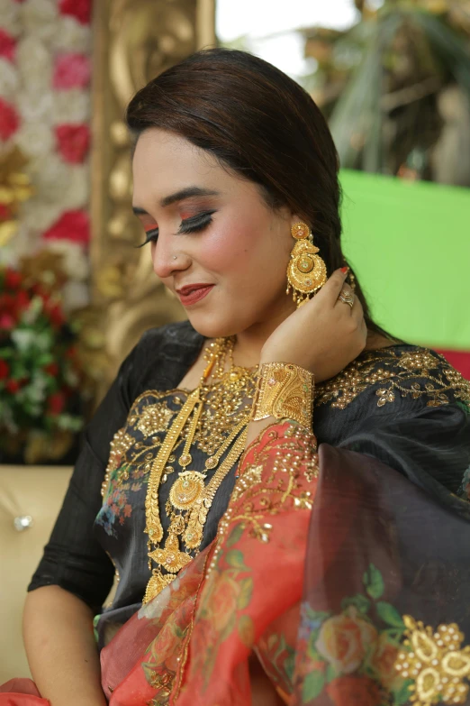 the woman wearing gold jewelry is standing