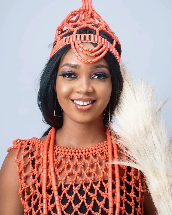 a woman in orange wearing an intricate beaded headdress