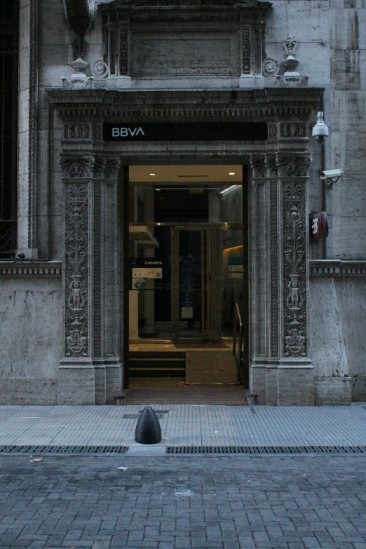 a tall building with a clock and a door in front of it