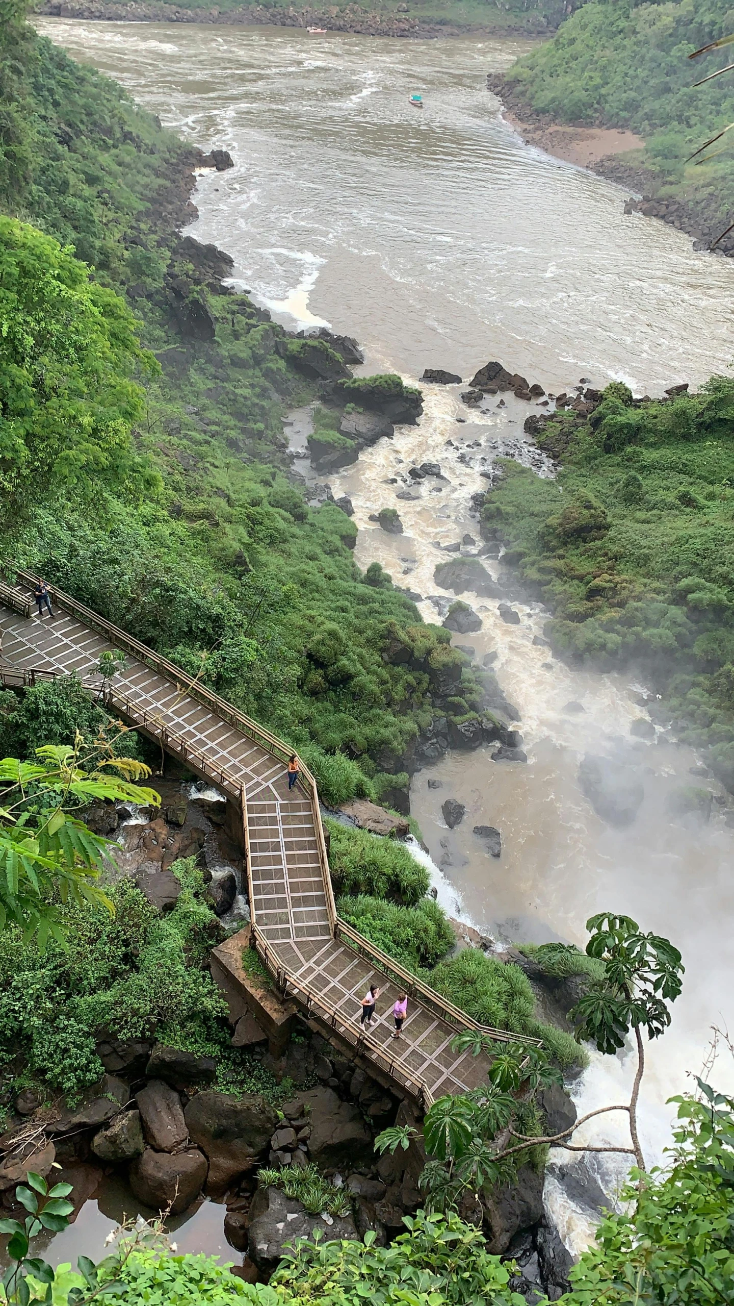 a walkway to the top of a hill above a river