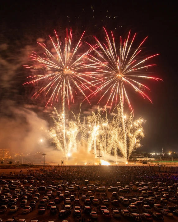 a huge firework display over a parking lot at night