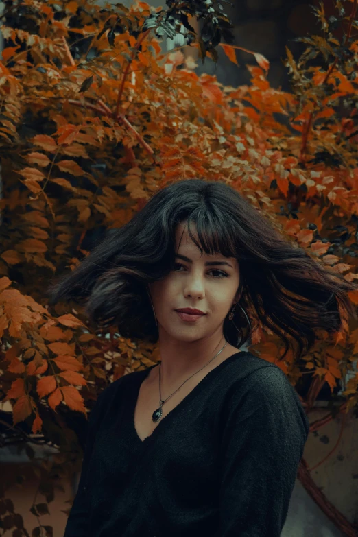 a girl with very long hair sitting next to orange tree