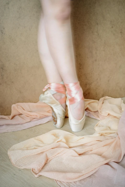 a person's foot and ballet shoes on top of clothes