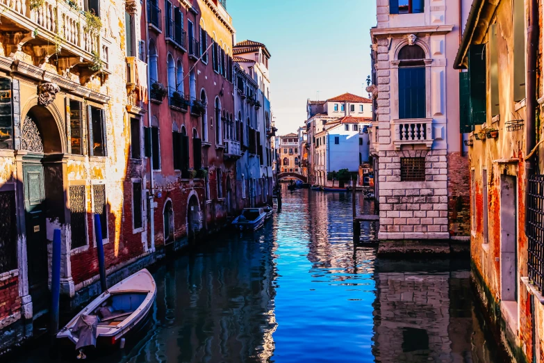 a boat is parked in the water beside a row of buildings