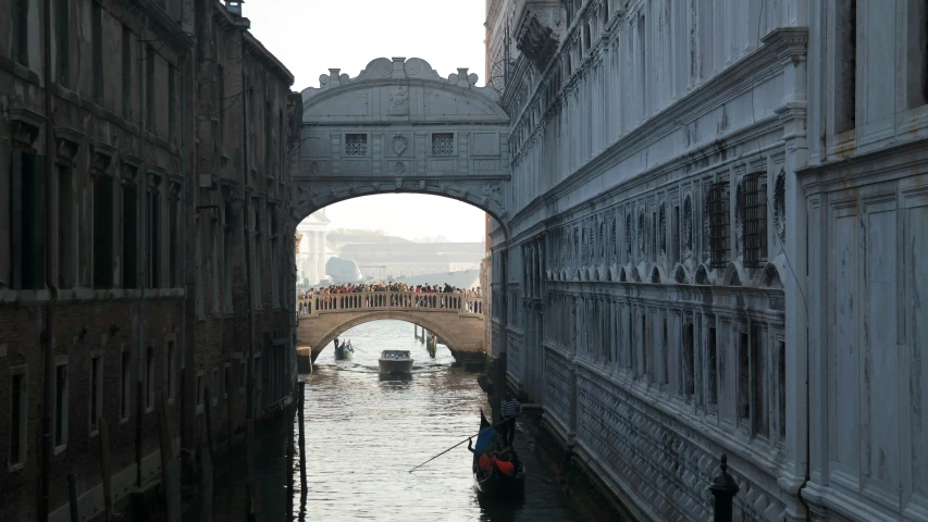 several boats sailing down a waterway in an old city