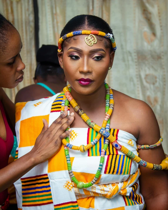 a woman in african costume getting ready for a carnival