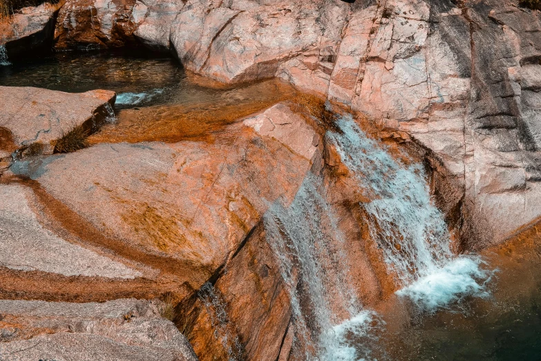 a rock waterfall that is flowing down into the water