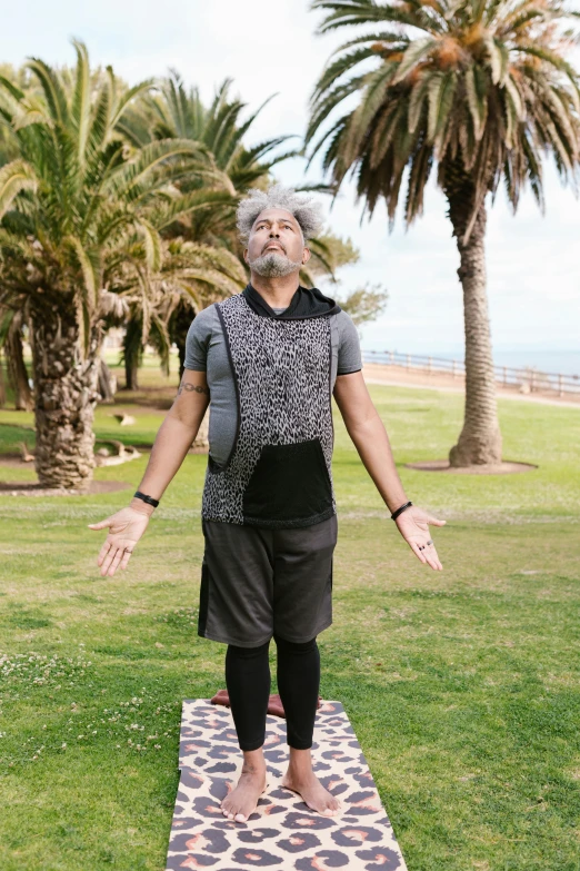 a person in shorts is on top of a mat in the grass