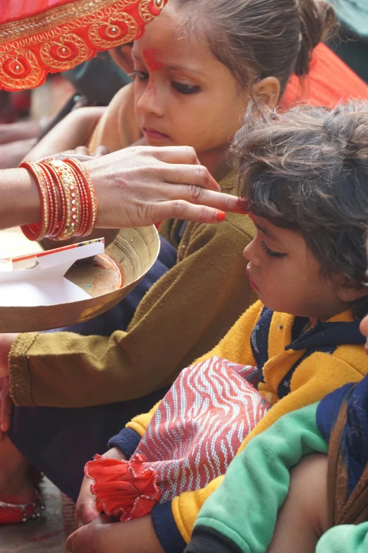 several people watching one hold a plate with a small child and a man holding the other