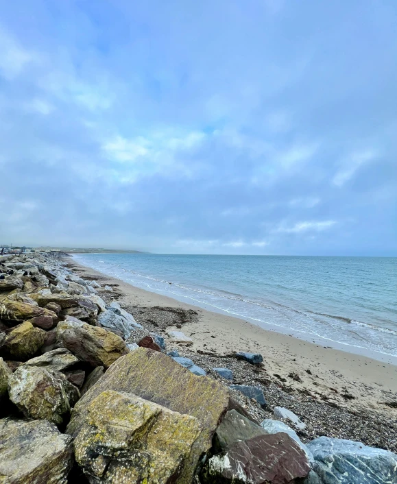 an ocean shoreline with large rocks and the ocean