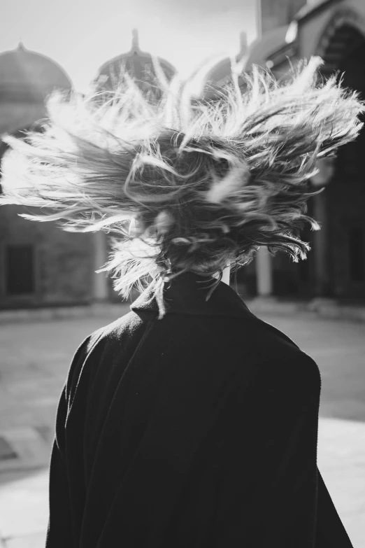 the back of a person standing near a building