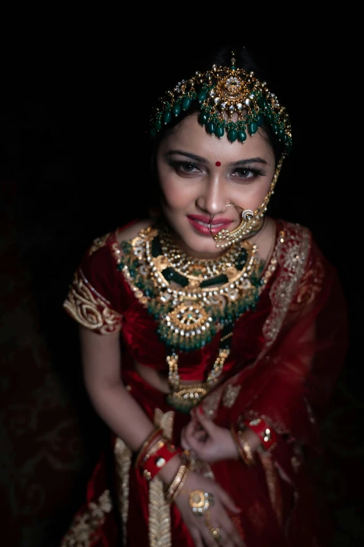 a woman in traditional garb smiles while wearing jewelry