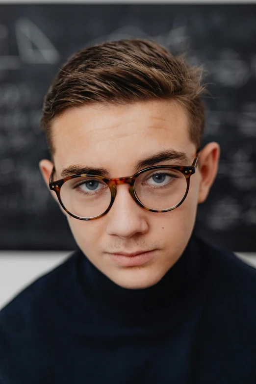 a boy with glasses looks at the camera