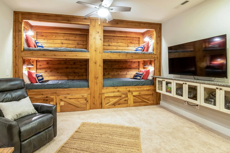 this bedroom has three large wooden bunk beds with pillows