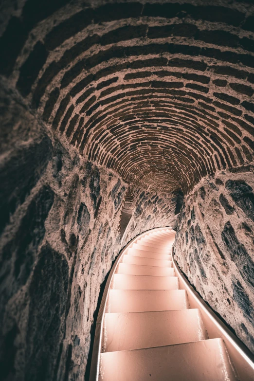 a dimly lit tunnel in a city with stone walls