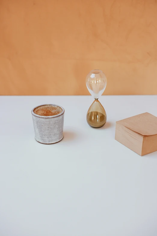 a small cup next to a gold and crystal container on a table