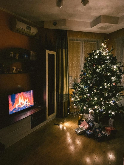 a lit christmas tree in a dark living room with lights on