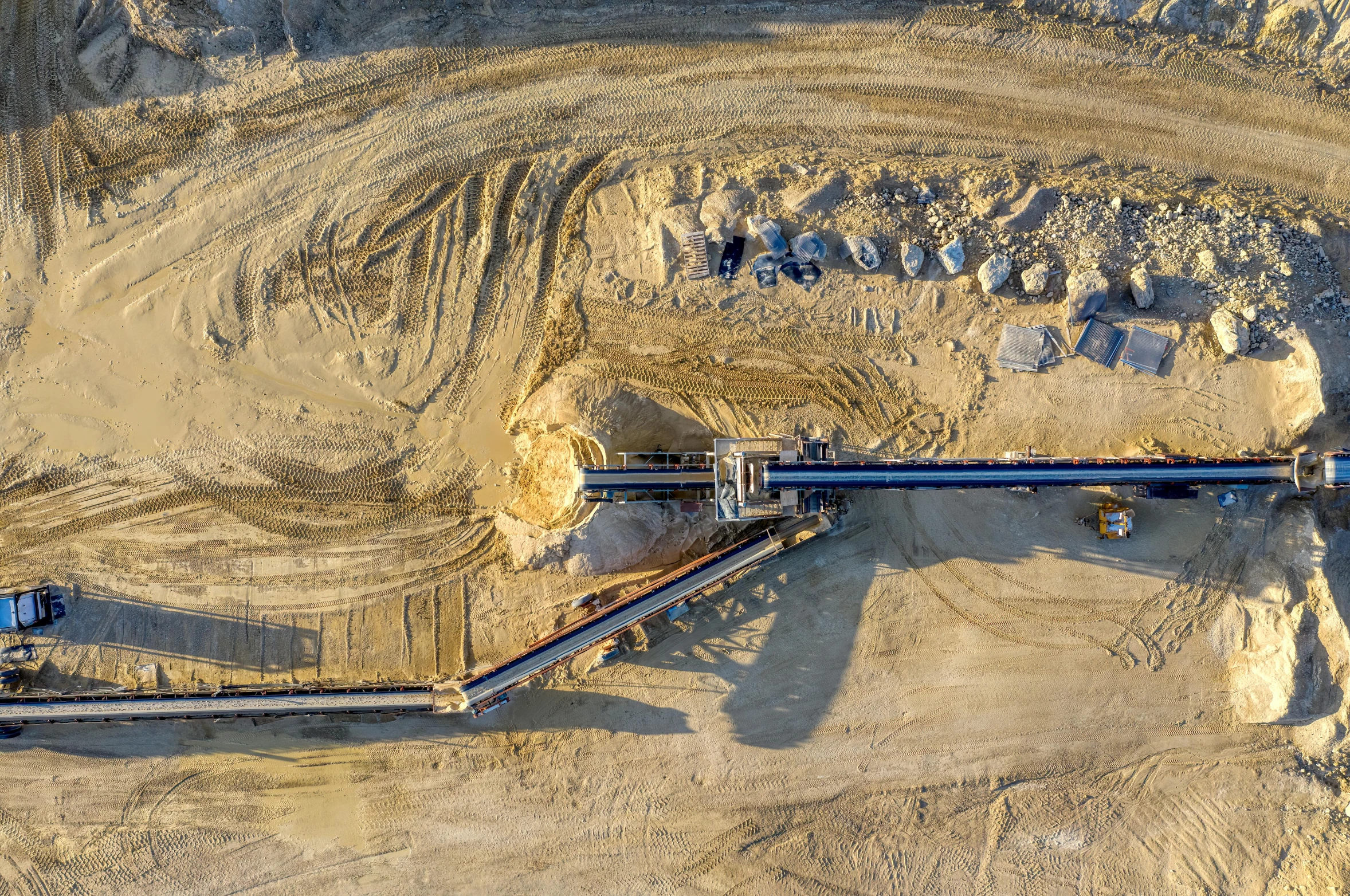 a train on some tracks surrounded by sand