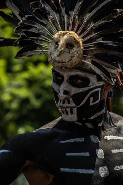 the man with a skeleton face is wearing a headdress