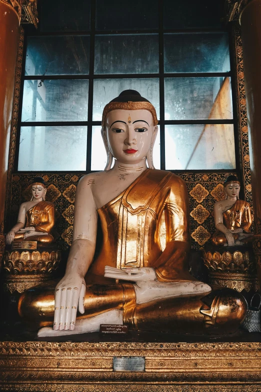 a large golden buddha statue sitting in a room