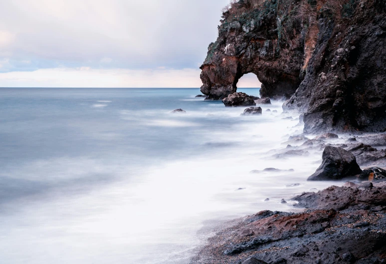 a view of the ocean and rocks along the shore