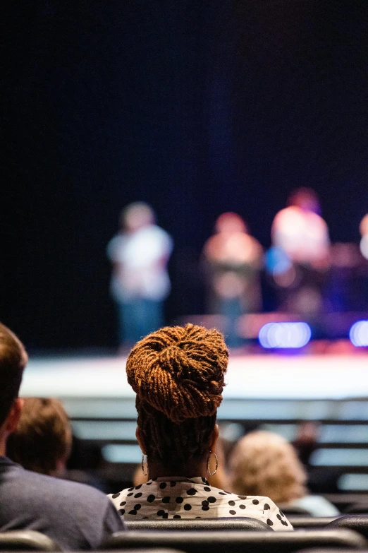 people are in an auditorium watching a concert