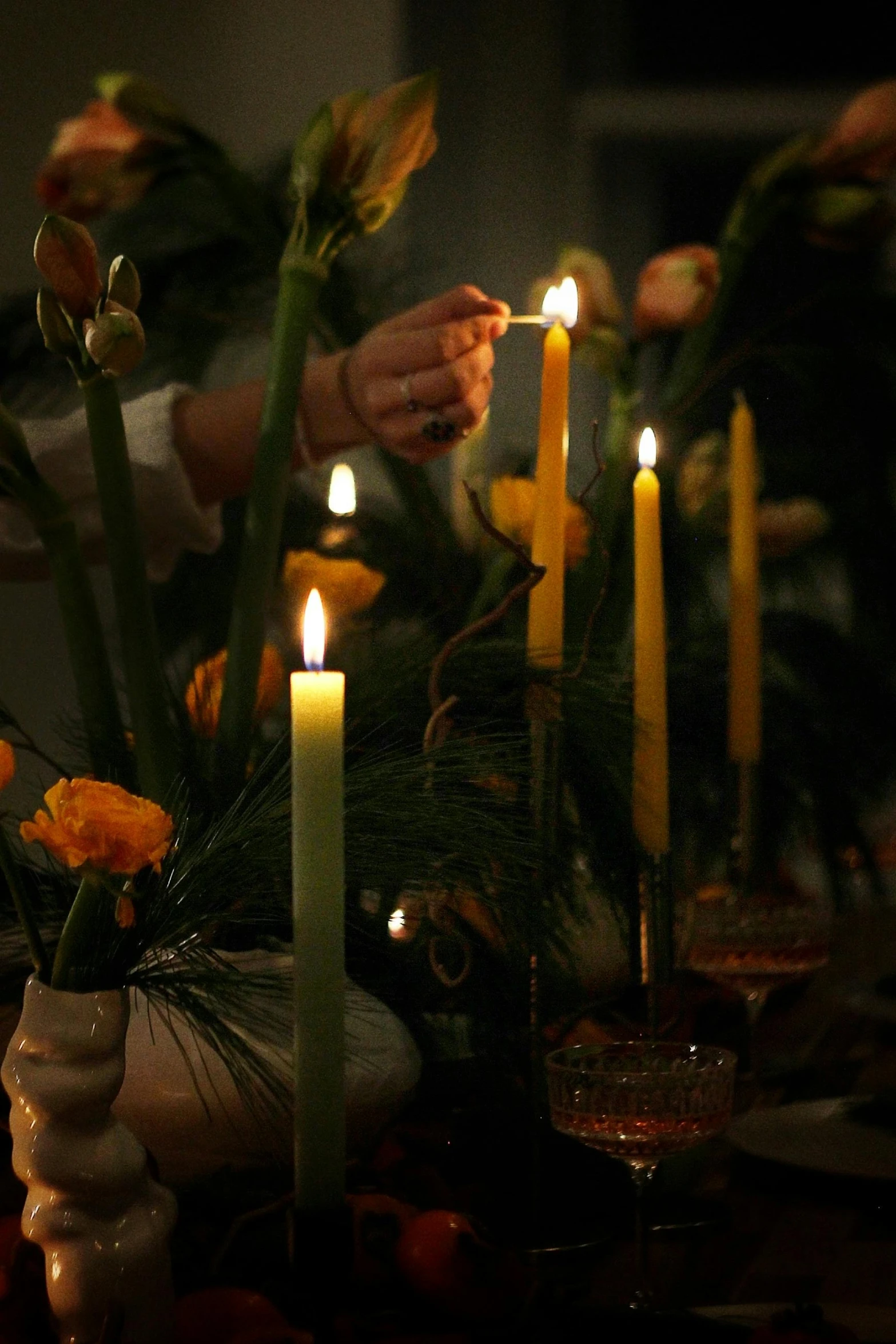 several candles lit on a table with flowers