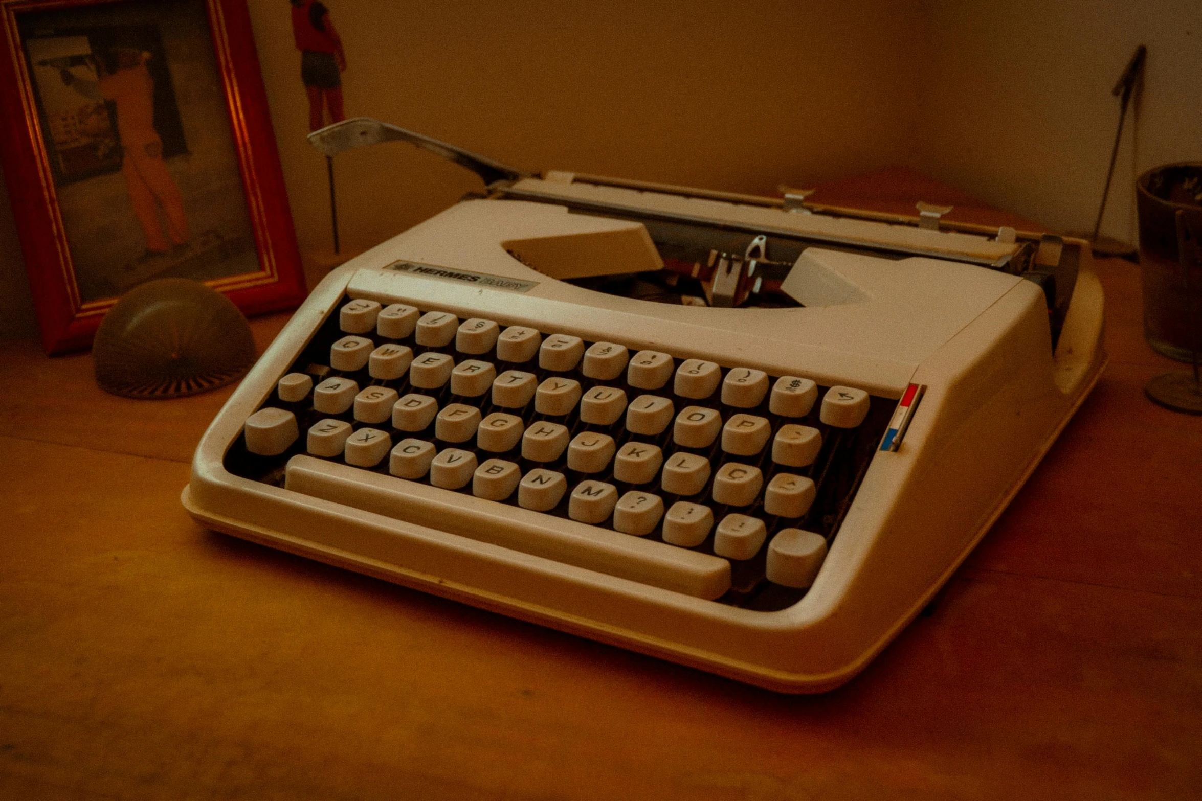 an old fashioned typewriter next to a picture frame