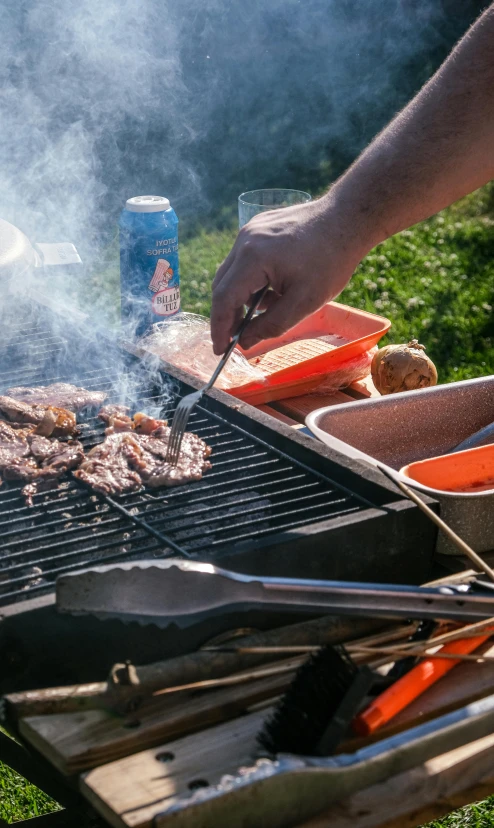 a person grilling  dogs on a bbq grill