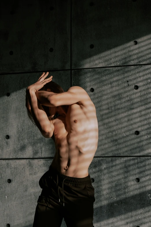 a young man leaning against the wall wearing 