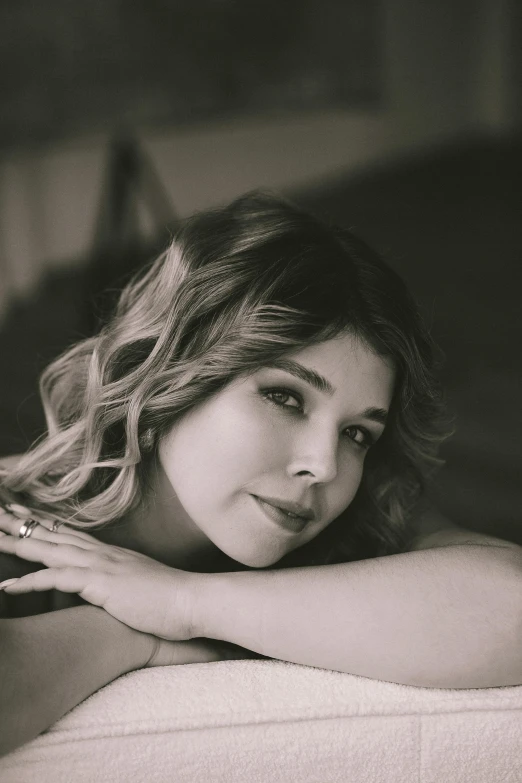 a young lady poses on the couch with her arms crossed