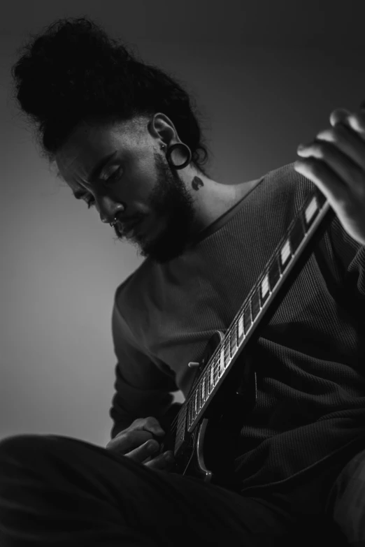 a man with a tattoo plays an electric guitar