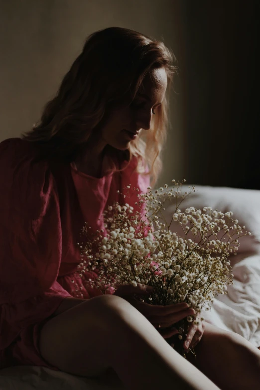  in bed smelling a bouquet of flowers