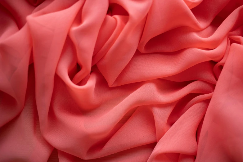 the folds of a red silk fabric closeup