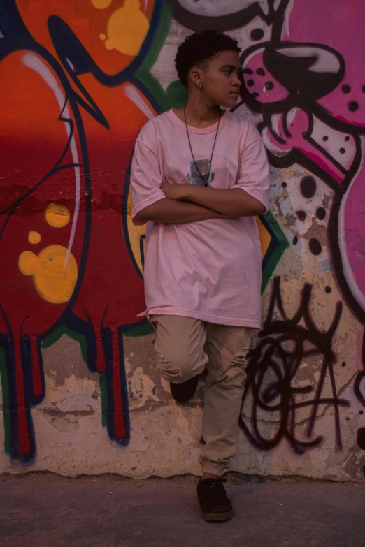 a man wearing headphones standing in front of graffiti on the wall