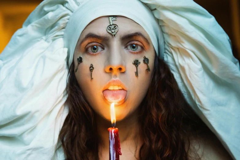 a woman wearing makeup holds a candle with other hands and puts lipstick on her lips