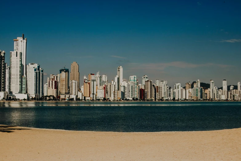 a sandy beach sitting next to a big city