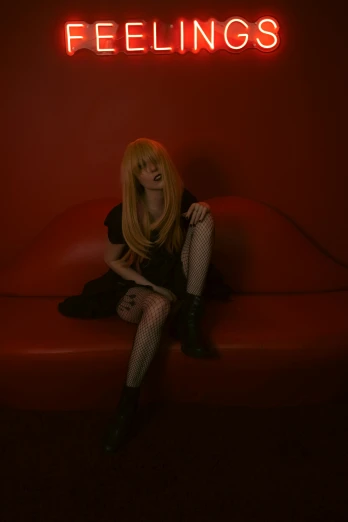 a woman sits on a red couch with the lights on