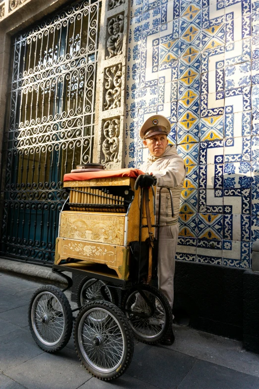 an old man hing his wagon along side of a building