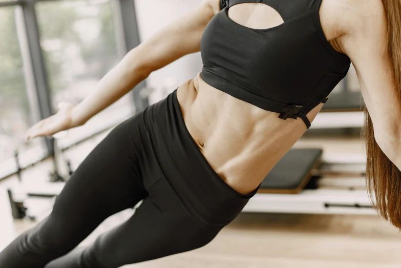 a woman in a black top does a side plank