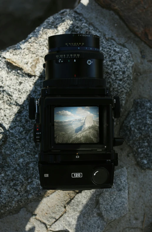 a close up of a camera with stone in the background