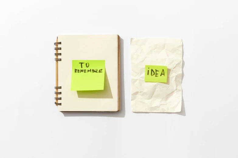 two sticky notes attached to a notebook in a room